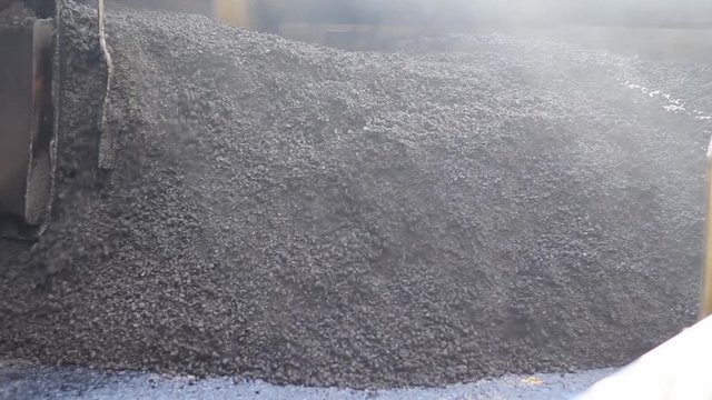grader bucket carries asphalt crumb