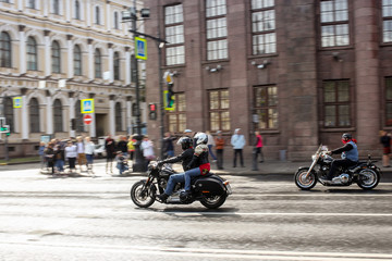 Obraz na płótnie Canvas A pair of motorcyclists pulls up to an intersection.