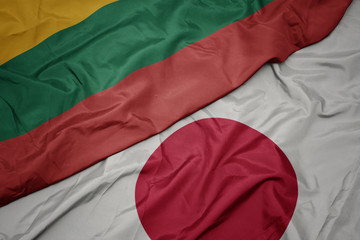 waving colorful flag of japan and national flag of lithuania.