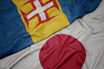 Fototapeta premium waving colorful flag of japan and national flag of madeira.