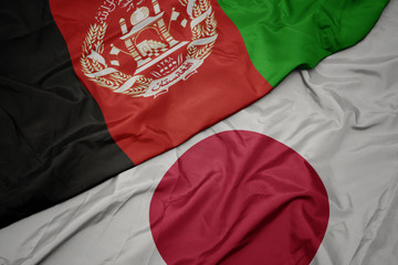 waving colorful flag of japan and national flag of afghanistan.