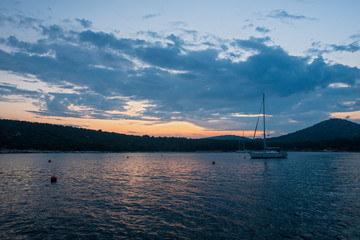Ankerndes Segelboot in einer Bucht im Mittelmehr bei Sonnenuntergang