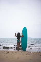 Beautiful asian sexy woman with surfboard on the beach.