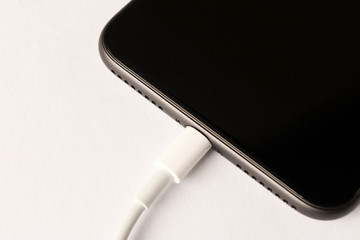 Smartphone on charge . On white background. Close up.