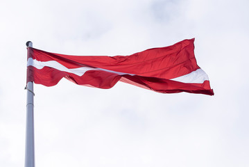 Latvia flag waving, flag of Latvia above Sky in Riga