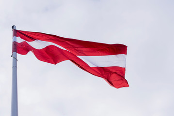 Latvia flag waving, flag of Latvia above Sky in Riga