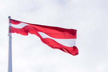 Latvia flag waving, flag of Latvia above Sky in Riga