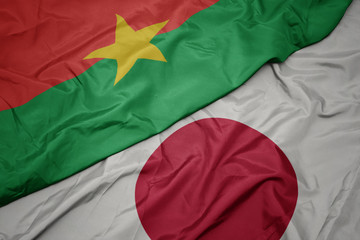 Fototapeta premium waving colorful flag of japan and national flag of burkina faso.