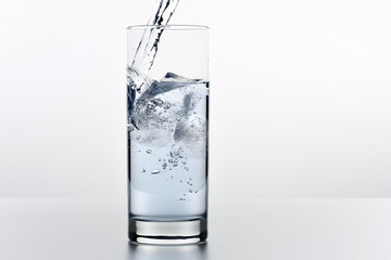 Beautiful splash of water in a glass with ice