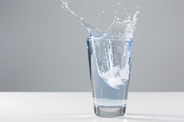 Beautiful splash of water in a glass with ice