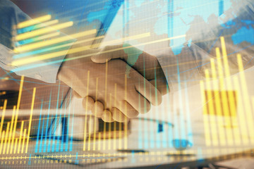 Multi exposure of financial chart and map on office background with two businessmen handshake. Concept of success in business