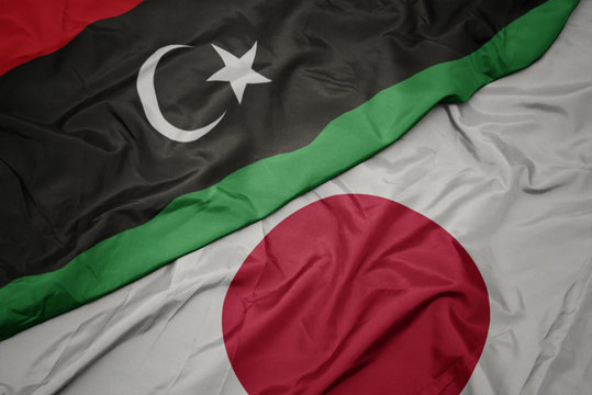 waving colorful flag of japan and national flag of libya.