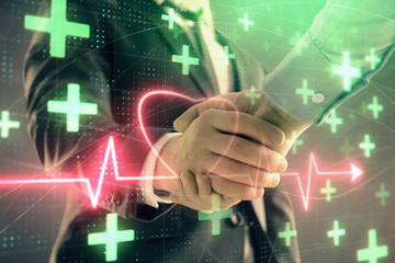 Multi exposure of heart hologram on abstract background with two men handshake. Concept of medical education