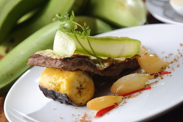 Roasted beef fillet with plantain, pumpkin and onion.
