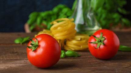 ripe tomatoes  raw fettuccine basil ingredients for cooking vegetarian pasta close up