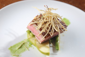 Roasted fresh tuna loin with garnish of apples, peas and tortilla strips.