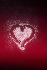 Heart of glitter on red background