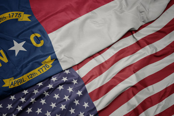 Obraz premium waving colorful flag of united states of america and flag of north carolina state.