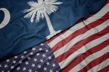 waving colorful flag of united states of america and flag of south carolina state.