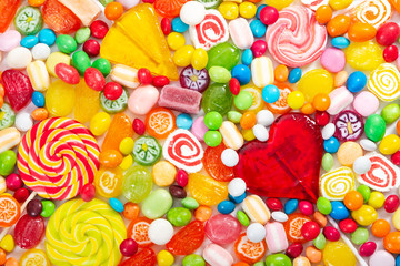 Fototapeta na wymiar Colorful lollipops and different colored round candy. Top view.