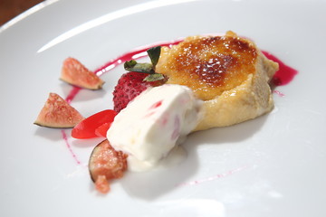 Fig dessert with vanilla ice cream and strawberries.