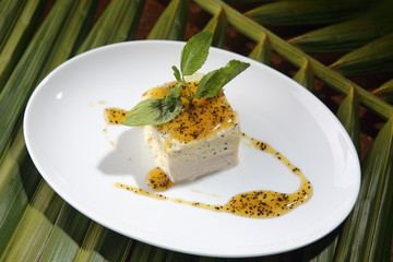 Vanilla dessert bathed in sweet mango and chocolate sauce.
