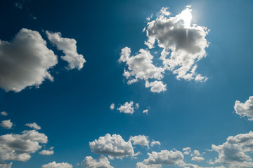 Naklejka na ściany i meble Noon bright sunny day, blue sky, the sun behind the cloud