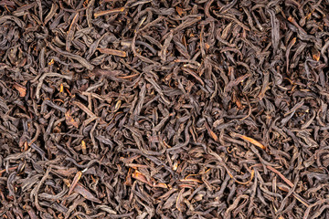 Black tea leaves background. Abstract food textures. Close up