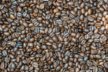 Roasted coffee beans in a background. Close up