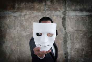 Businessman holding white mask in his hand dishonest cheating agreement.Faking and betray business...