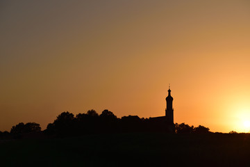 dark silhouette of a small village in Germany with church in the sunset