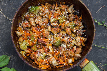 meat broccoli carrots onions garlic with sesame seeds all together in a pan.