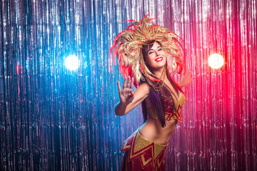Carnival, dancer and holiday concept - Beauty brunette woman in cabaret suit and headdress with...