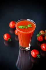 homemade tomato juice in a glass and fresh tomatoes