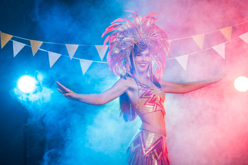 Carnival, belly dance and holiday concept - Beautiful female samba dancer wearing gold costume and...