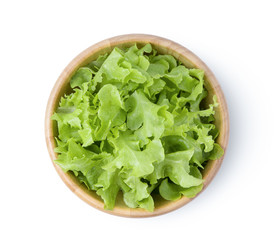 lettuce leaf in wood bowl isolated on white background. top view