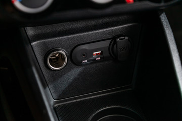 Close up of a charging in the car, cigarette lighter, aux, usb connectors. modern car interior.