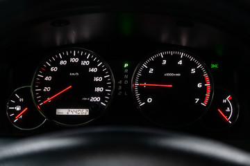 Fototapeta premium Car dashboard with white backlight: Odometer, speedometer, tachometer, fuel level, water temperature and more.