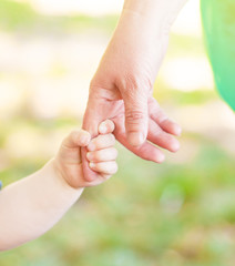 Close up old woman and a kid holding hands together