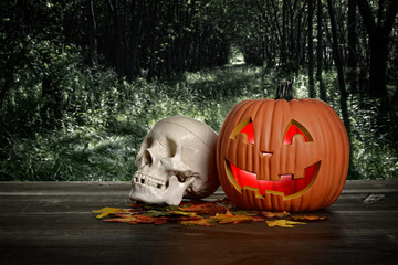 halloween pumpkin and skull in the evening on wood table