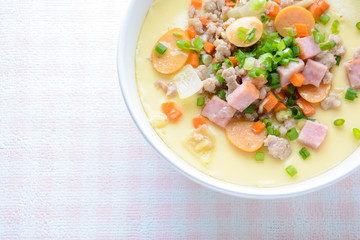 Steamed egg custard cuisine in a white bowl with minced pork, sausage and bacon.  Or Only with egg, water, salt and some sesame oil, you can make this super smooth custard at home.