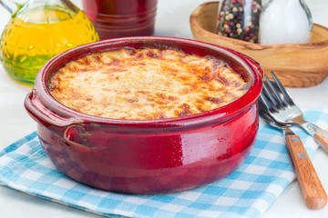 Greek dish moussaka made in  traditional ceramic pot, horizontal, closeup