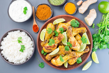 Indian chicken tandoori, marinated in greek yogurt  and spices, served with lime wedges and cilantro, horizontal, top view