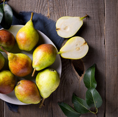 Harvest concept. White bowl with a bunch of juicy pears closeup