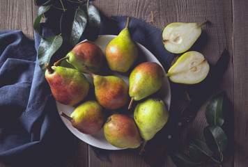 Harvest concept. White bowl with a bunch of juicy pears closeup