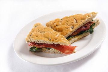 Traditional bread sandwich with serrano ham, cheese and spinach leaves.