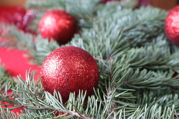Green fir branch with red balls on a red background for a Christmas card.