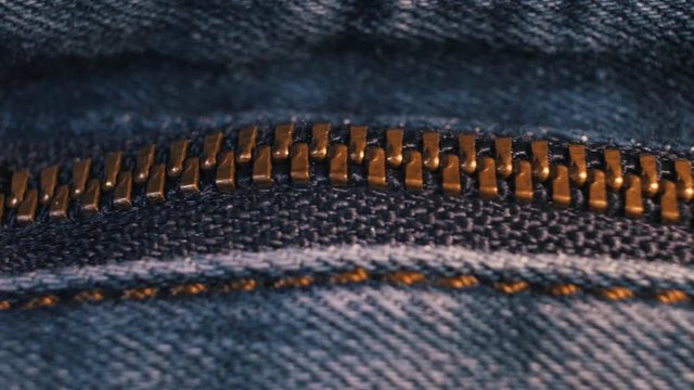 Denim zipper shot in close-up with a smooth camera movement from right to left