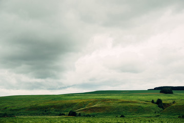 bad weather in summer day, dark dramatic rainy sky clouds over agricultural rural landscape, horizontal stock photo image