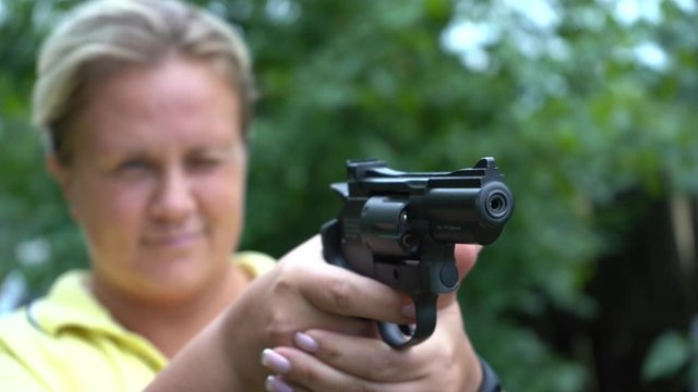The girl shoots from a pneumatic pistol. Weapons in female hands. A shot from a pistol.